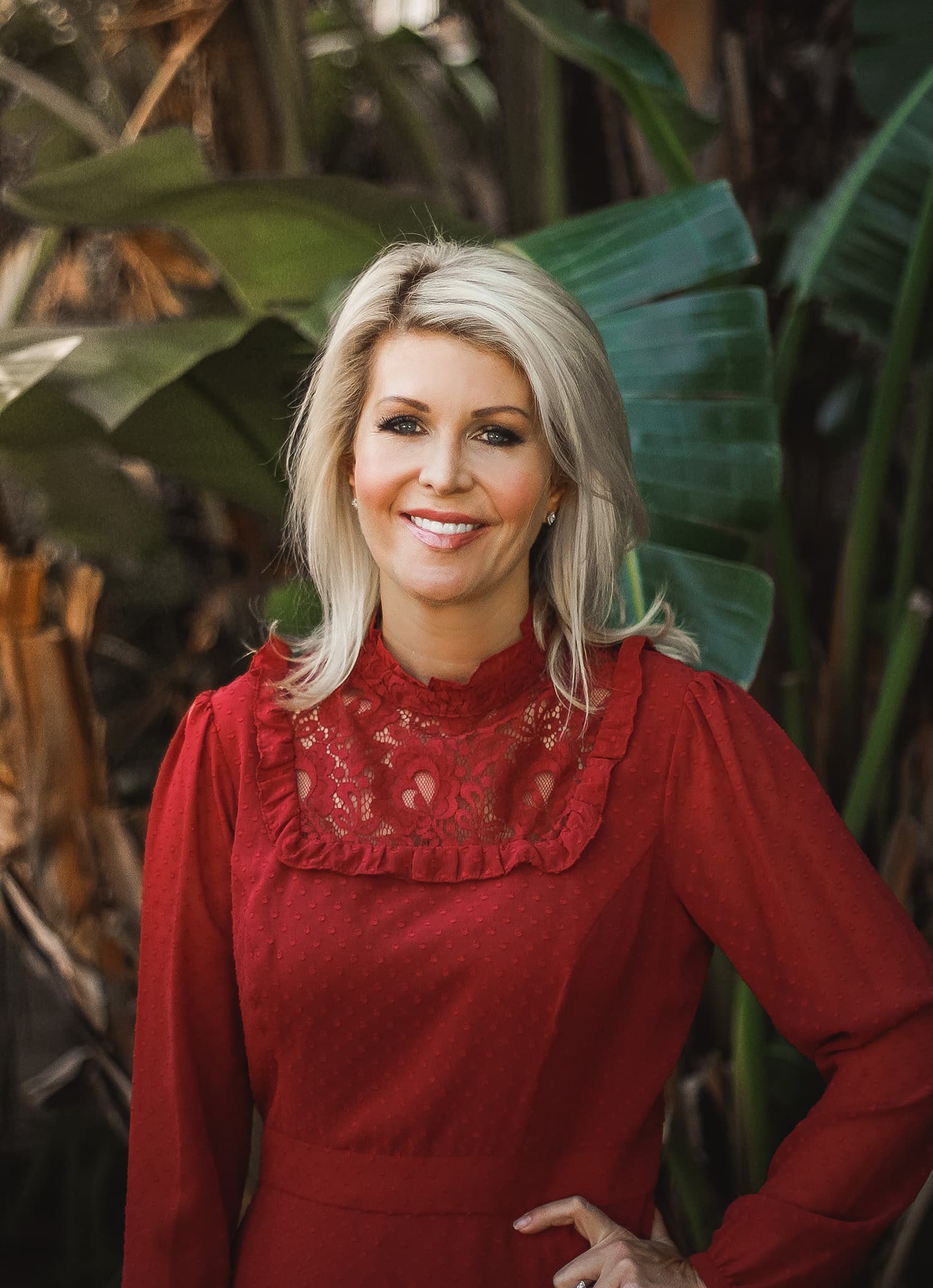 Chezzi Denyer in a red dress amongst banana leaves